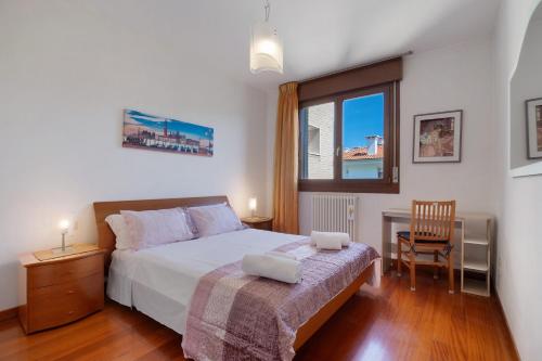 a bedroom with a bed and a chair and a window at Casa Andrea in Venice