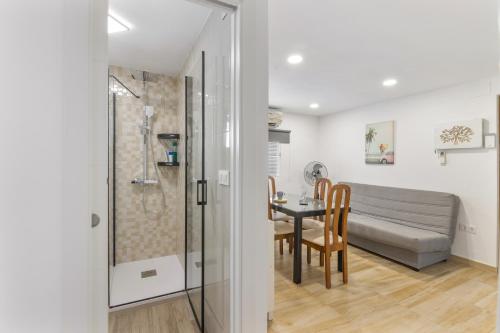 a bathroom with a shower and a table with chairs at Encanto Costero in Ayamonte