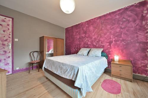 a bedroom with a bed and a pink wall at Pays De L'ours - Pyrénées in Melles