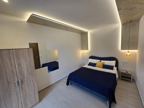 a bedroom with a blue bed and a mirror at Casa Mia Holiday House in Pianillo