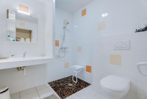 a white bathroom with a toilet and a sink at Grain de sable in Saint-Benoît-des-Ondes
