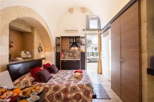 a bedroom with a bed and a table with food on it at Monolocale Delux Alithia in Muro Leccese