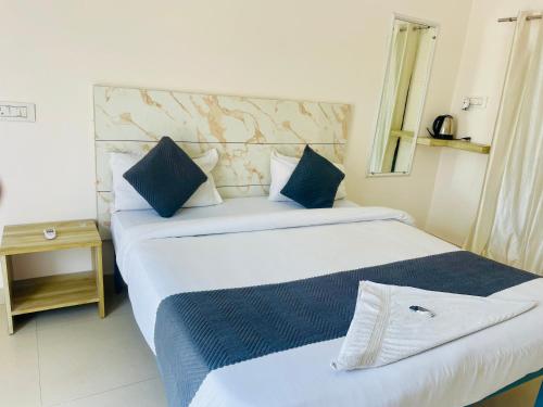a bedroom with two beds with blue and white pillows at Hotel The regal inn in Varanasi