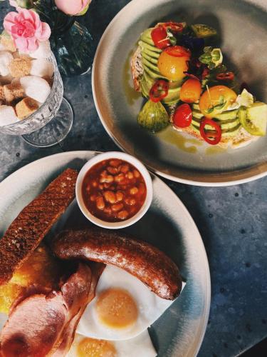 a table with two plates of food with sausage and beans at Beds at 46, Cowes in Cowes