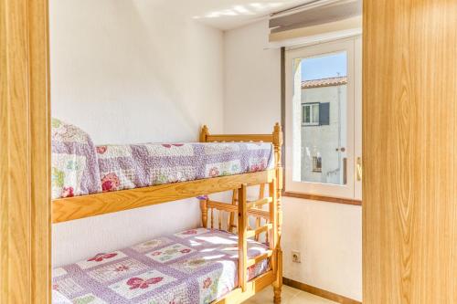 a small bedroom with bunk beds and a window at San Enrique in L'Escala