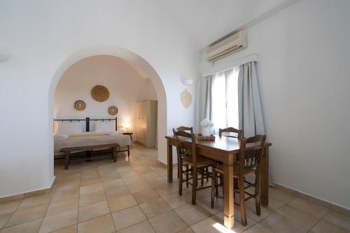 a living room with a dining room table and a bedroom at Kythiris Studios in Kálamos Kythira