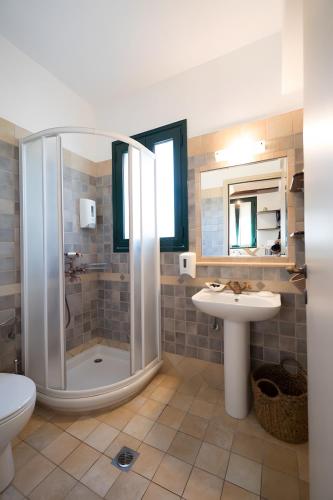 a bathroom with a shower and a sink and a toilet at Kythiris Studios in Kálamos Kythira