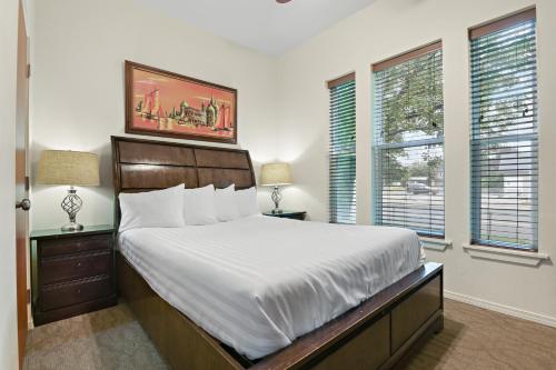 a bedroom with a large bed and two windows at Maple Leaf Manor Suites in Spokane