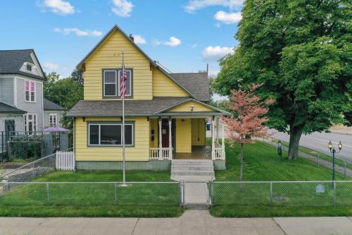 a yellow house with a flag in front of it at Maple Leaf Manor Suites in Spokane