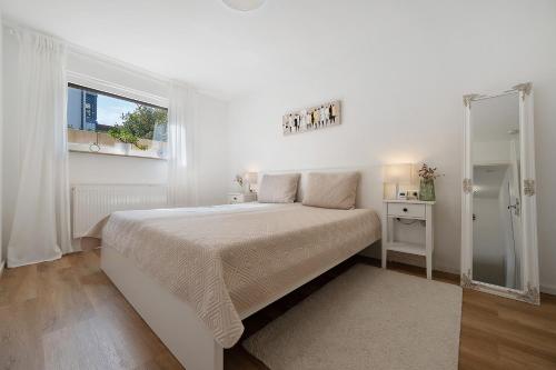 a white bedroom with a large bed and a window at Ferienwohnung Auszeit in Calw