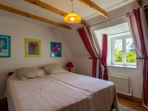a bedroom with a bed with red curtains and a window at Gites Air Marin in Lannion