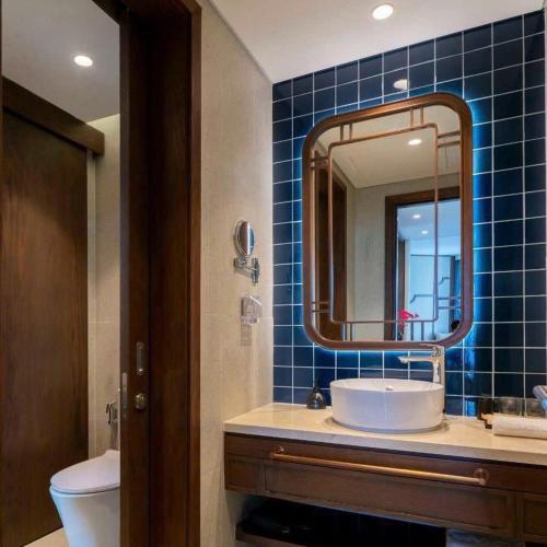 a bathroom with a sink and a mirror at Apec Beach Luxury Mũi Né in Mui Ne