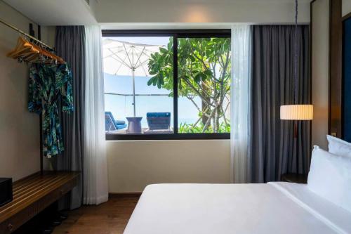 a hotel room with a large bed and a window at Apec Beach Luxury Mũi Né in Mui Ne