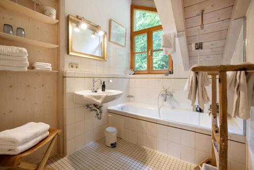 a bathroom with a tub and a sink at Ferienhaus Chalet Montfort in Sonthofen