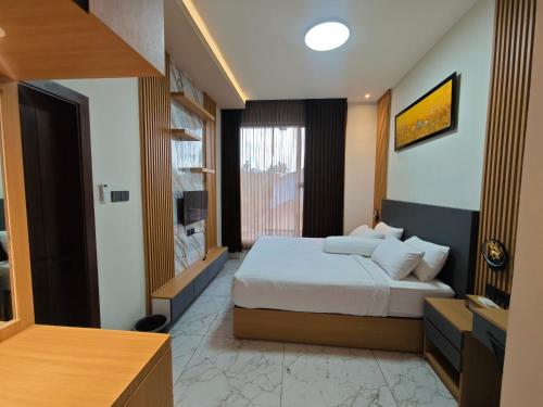 a hotel room with a bed and a television at AIRO Villas in Sultan Syarif Kasim II International Airport