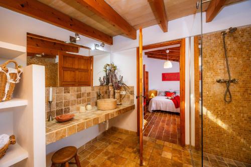 a bathroom with a walk in shower and a sink at Can Bleo in Pollença