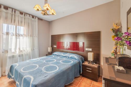 a bedroom with a large bed with a blue blanket at El Rellano in Maluenda