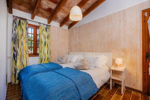 a bedroom with a large bed with a blue blanket at Can Bleo in Pollença
