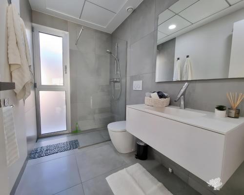 a white bathroom with a sink and a toilet at Tipuana 7 in Orihuela
