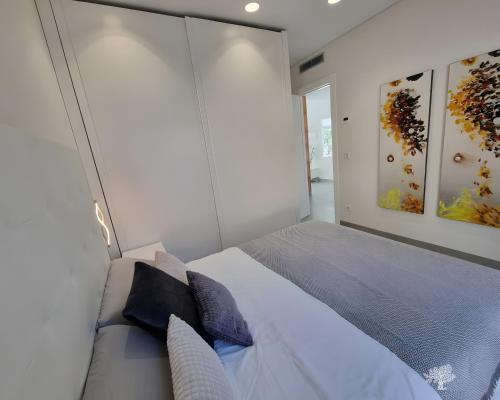 a bedroom with a large white bed with blue pillows at Tipuana 7 in Orihuela