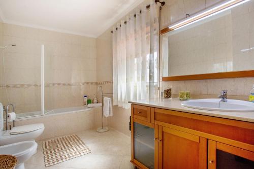 a bathroom with a sink and a tub and a toilet at Casa da Cândida in Nazaré