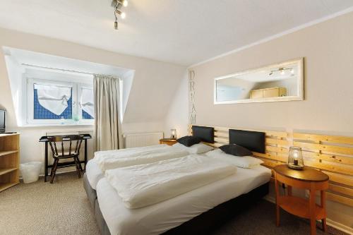a bedroom with a large bed and a table at Pension Neuenrade in Neuenrade