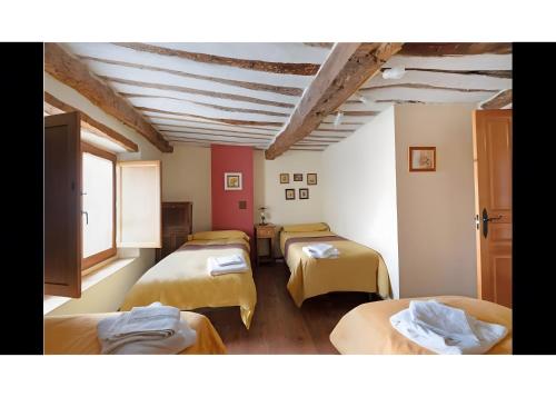 a room with four beds in a room with a ceiling at Casa Llano in Llano de Bureba