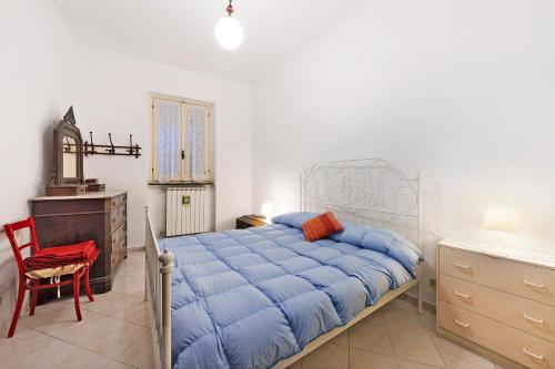 ein Schlafzimmer mit einem blauen Bett und einem roten Stuhl in der Unterkunft Giomar in Levanto