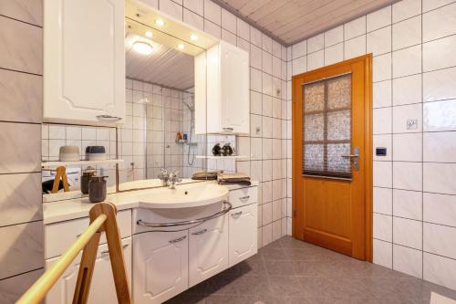 a white bathroom with a sink and a mirror at Alte Schmiede in Kuden