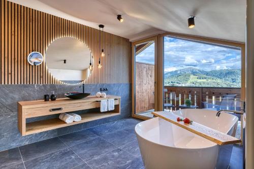 a bathroom with a tub and a sink and a mirror at Chalet Schlossberg Schwarzhorn in Nova Ponente