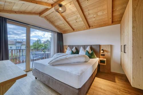 a bedroom with a large bed and a large window at Chalet Schlossberg Schwarzhorn in Nova Ponente
