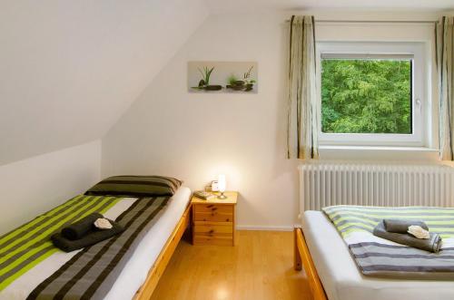 two twin beds in a room with a window at Ferienwohnung Härtel in Bad Zwischenahn
