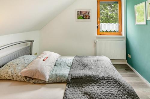 a bedroom with a bed with a gray comforter and a window at Fewo3 Buppeape Saterland in Bollingen