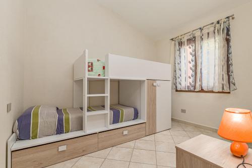 two bunk beds in a room with a desk and a table at Villetta Lu Lioni in San Teodoro
