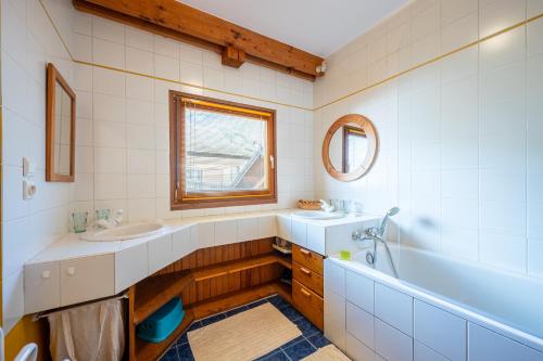 a bathroom with a sink and a tub and a mirror at chalet pierre et bois in Aigueblanche