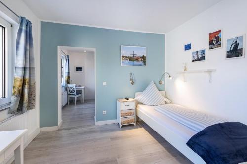 a bedroom with blue walls and a bed and a desk at Friesenstube in Kerken