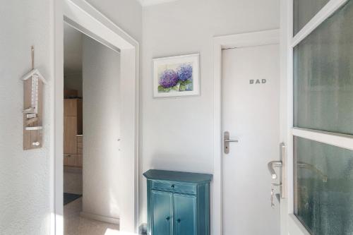 a bathroom with a blue cabinet next to a door at Idyllic Lakeside Cottage in Bockhorn