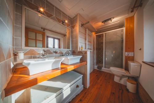 a bathroom with two sinks and a toilet at Le Cottage des Pléiades in Les Angles