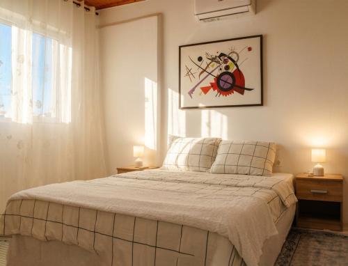 a bedroom with a bed and a picture on the wall at The Beach White House - 80m from the Beach - Renovated in Áyios Yeóryios