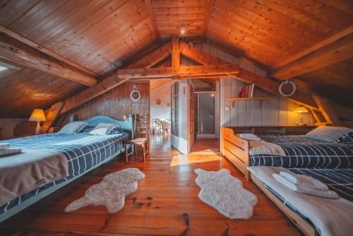 two beds in a room with wooden ceilings at Le Cottage des Pléiades in Les Angles