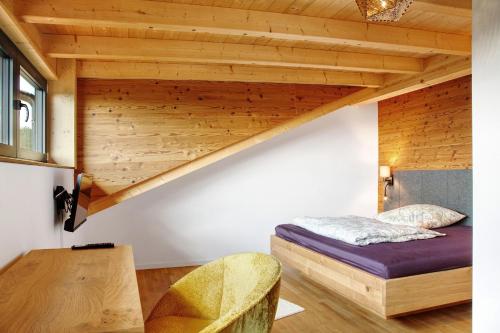 a bedroom with a bed and a wooden ceiling at Chalet Sonnenwald in Grattersdorf