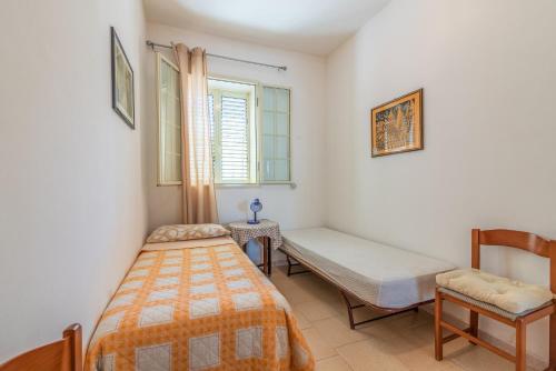 a bedroom with a bed and a bench and a window at Casa Nico in Augusta
