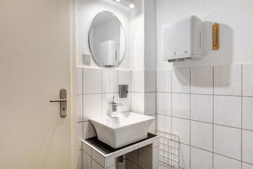 a white bathroom with a sink and a mirror at Pension Neuenrade in Neuenrade