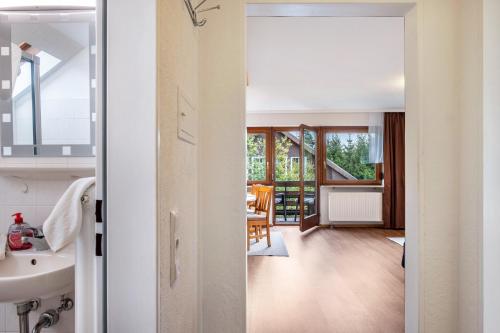 a bathroom with a sink and a room with a table at Ferienhaus Völkle in Hinterzarten