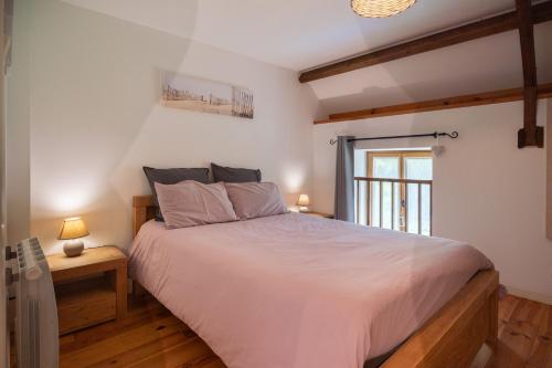a bedroom with a large white bed and a window at Domaine de Lestroué - Île d'arz in La Vraie-Croix