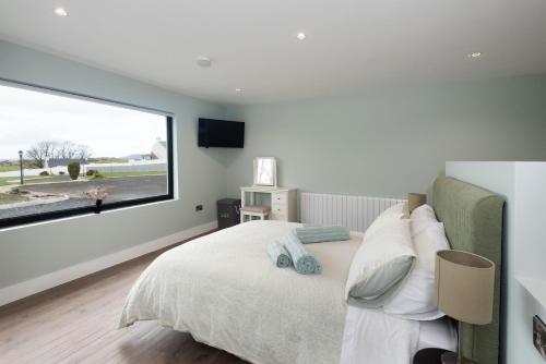 a bedroom with a bed with a large window at Ocean Breeze Apt 3 in Dunfanaghy