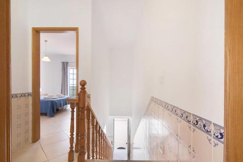 a hallway with a staircase with a blue and white wall at Moradia Altura in Altura