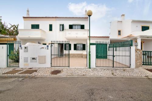 a white house with a gate in front of it at Moradia Altura in Altura