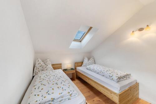 a bedroom with two beds and a skylight at Apartment Weingut Zail in Appiano sulla Strada del Vino