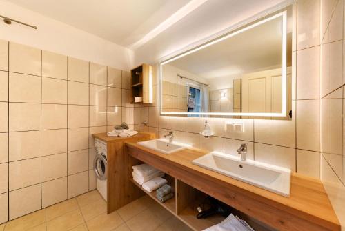 a bathroom with two sinks and a mirror at Apartment Weingut Zail in Appiano sulla Strada del Vino